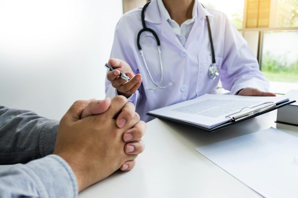 patient listening intently to a male doctor explaining patient symptoms or asking a question as they